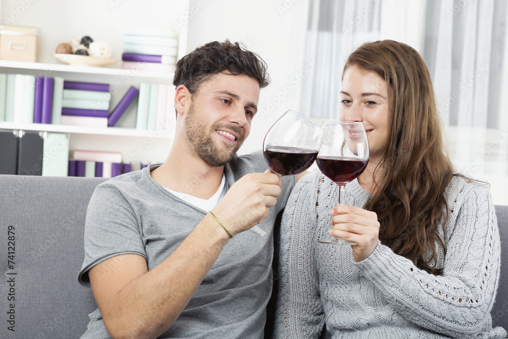 Junges Pärchen trinkt zuhause Rotwein Junges Pärchen trinkt zuhause Rotwein