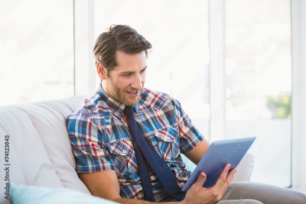 Casual man using tablet on the couch