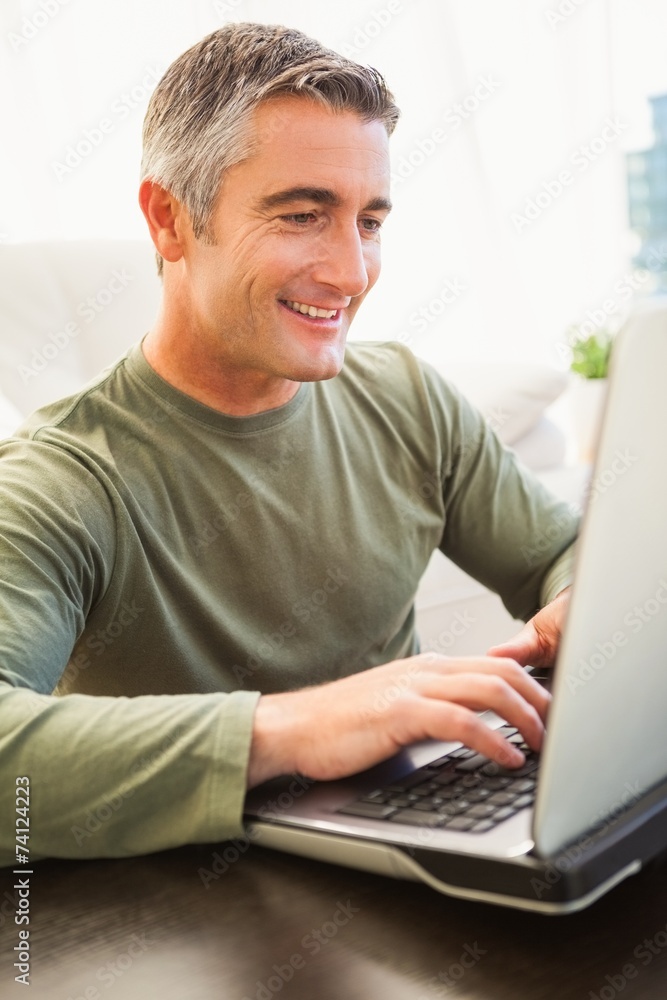 Smiling man with grey hair using laptop Smiling man with grey hair using laptop