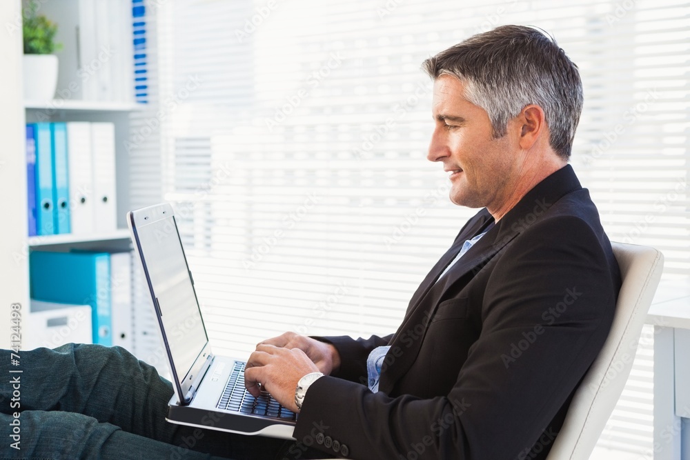 Cheerful businessman using laptop and relaxing Cheerful businessman using laptop and relaxing