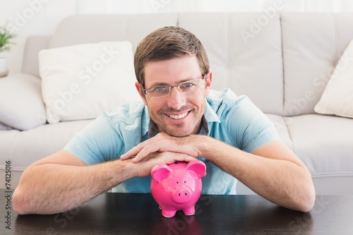 Smiling man with a piggy bank