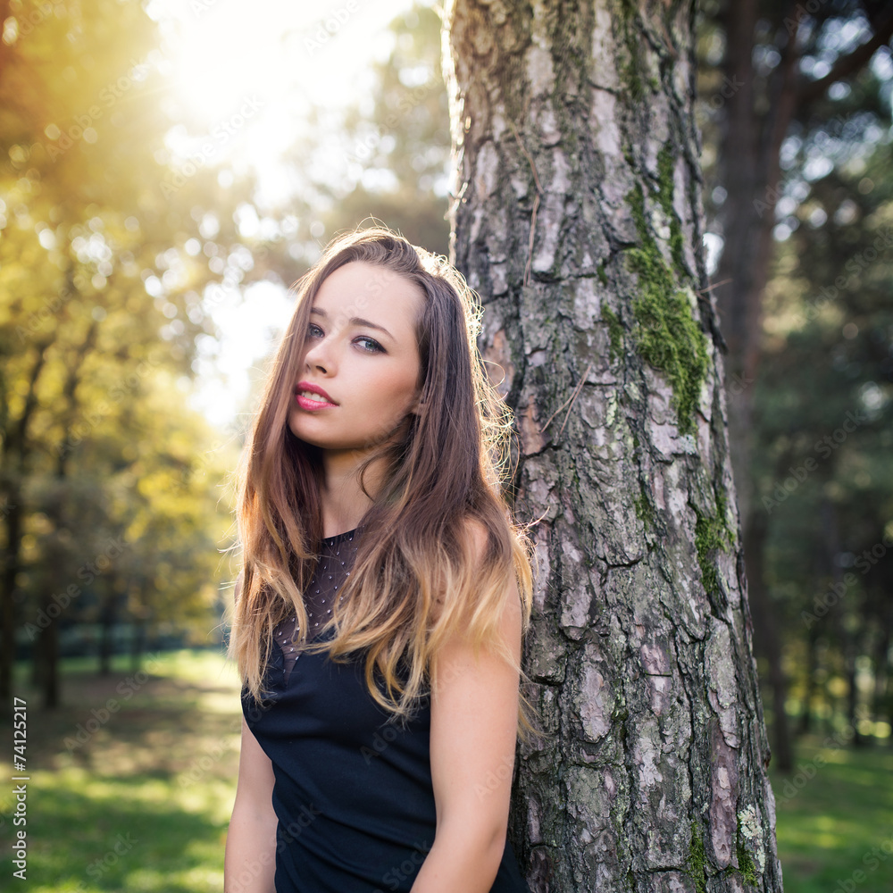 Intense young woman close up fashion portrait outdoors in a park Intense young woman close up fashion portrait outdoors in a park