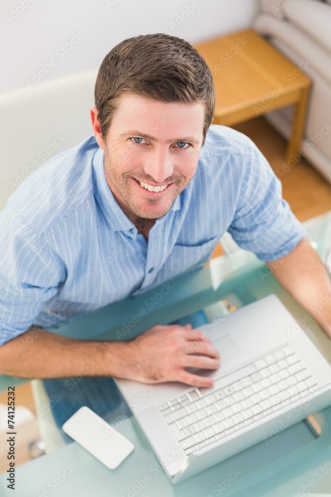 Smiling businessman using his laptop at desk Smiling businessman using his laptop at desk
