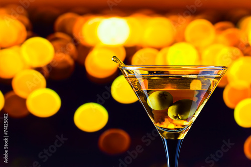 glass with martini and green olives