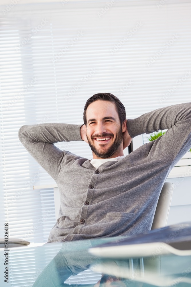 Relaxed casual businessman leaning back at his desk Relaxed casual businessman leaning back at his desk
