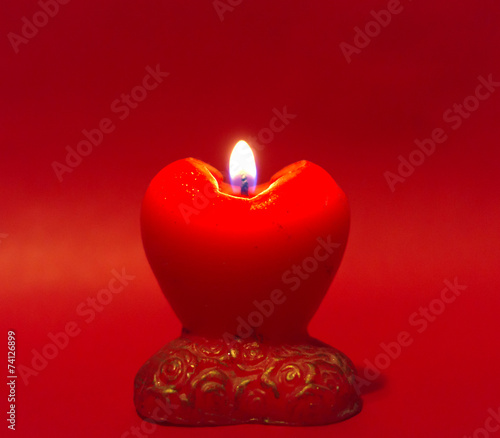 Obraz na płótnie Red heart candle on red background w salonie