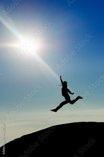 Silhouette man jumping toward sun