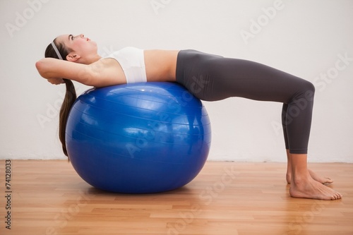 Fit brunette working out with exercise ball