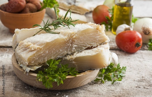 salted codfish on the wooden table with ingredients photo