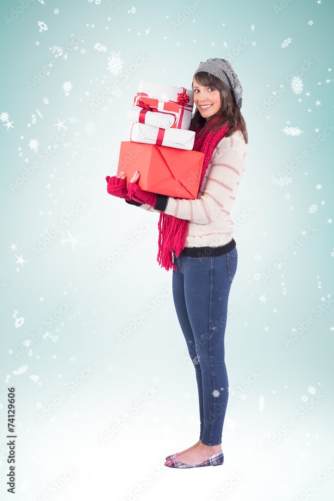 Composite image of pretty woman holding pile of gifts Composite image of pretty woman holding pile of gifts