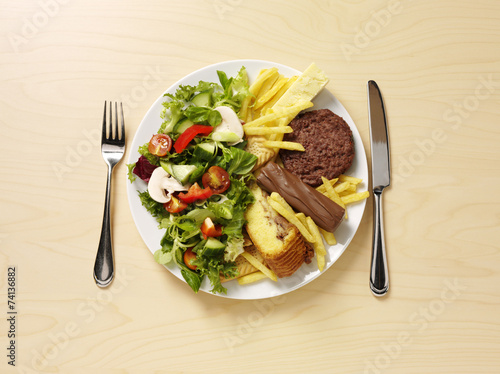 A plate filled half with unhealthy and healthy food