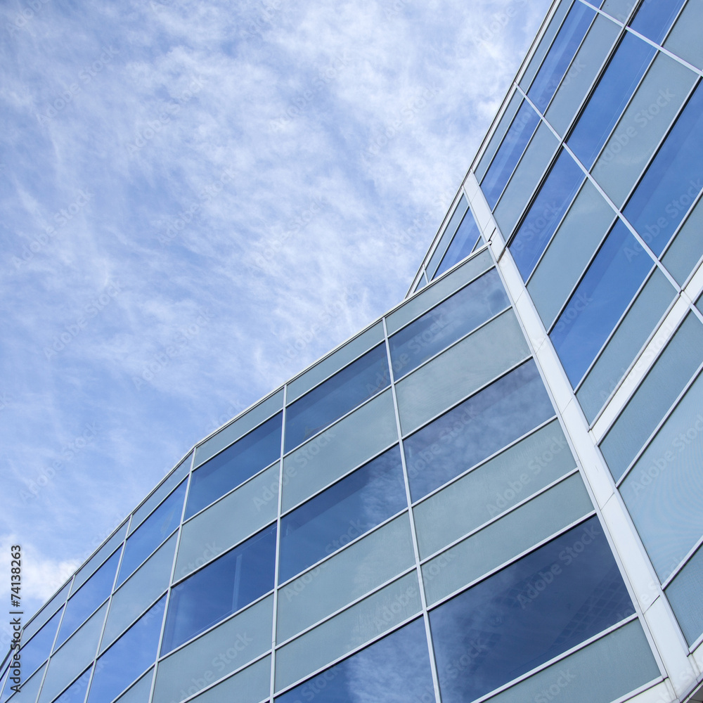 Obraz premium facade of glass and steel with reflections of blue sky