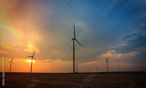 Rotating wind turbines at sunset
