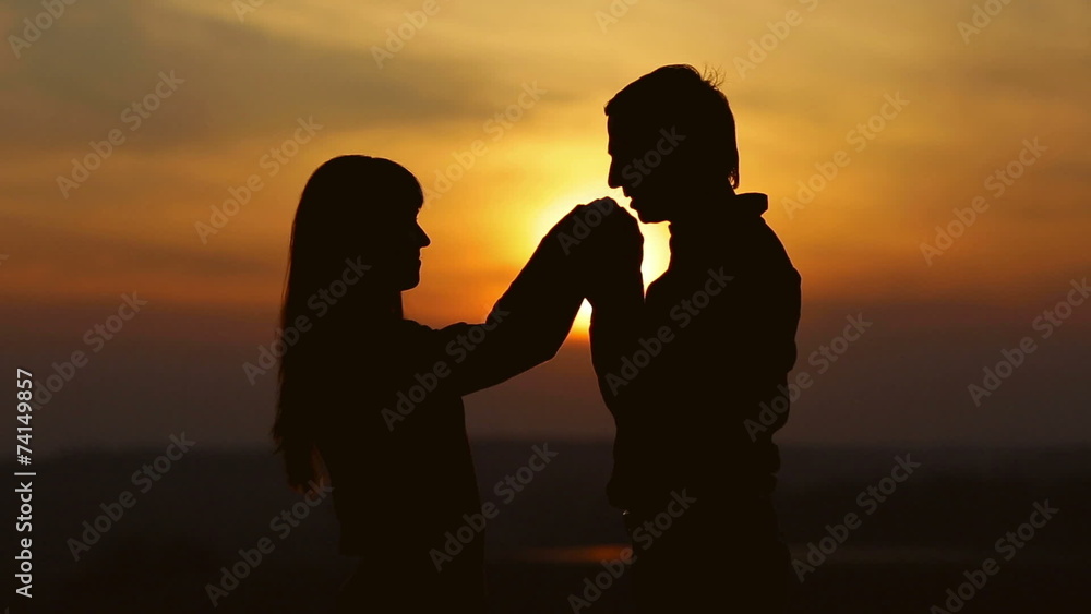 The pair, lovers, stand by sunset background on the top The pair, lovers, stand by sunset background on the top