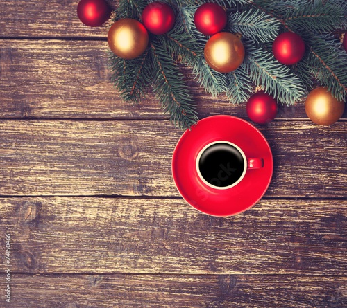 Cup of coffee next to pine bracnch on wooden table. photo