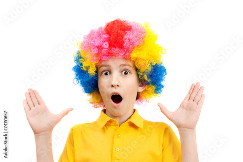 surprised the boy in the bright multi-colored wig