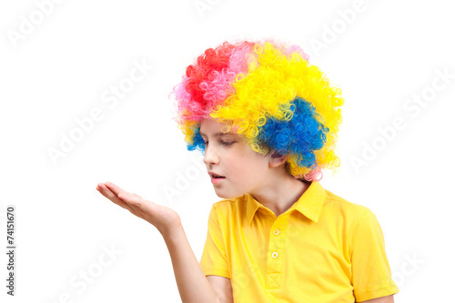 The boy in clown wig blowing on the palm