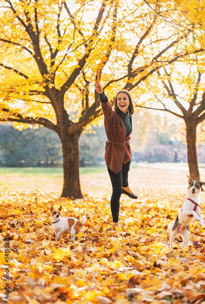 Happy young woman playing with dogs outdoors in autumn Happy young woman playing with dogs outdoors in autumn