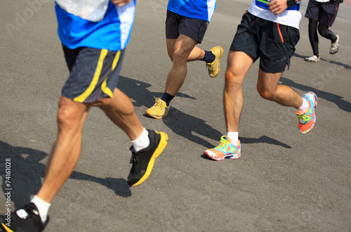 Unidentified marathon athletes legs running on street 