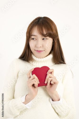 Smiling young asian woman with red heart shape