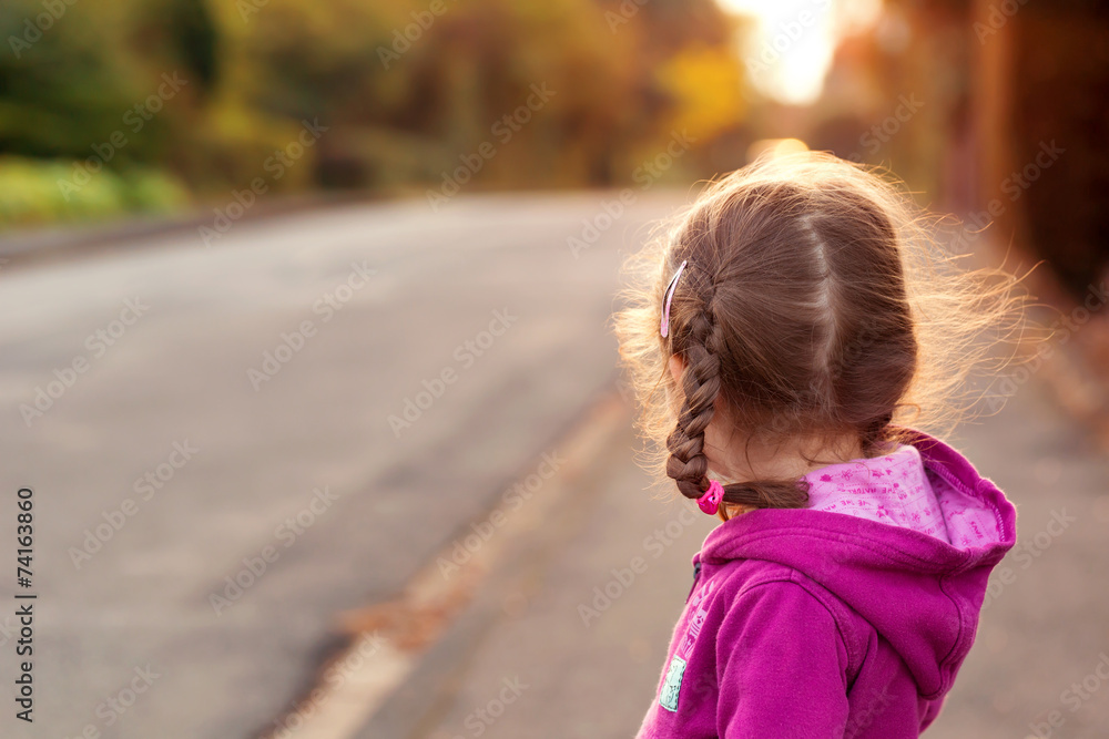 Little girl looking to cross the street. Rear view. Little girl looking to cross the street. Rear view.