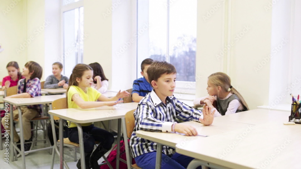 group of students with pens sitting at school