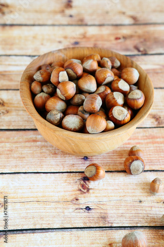 hazelnuts with shell in a wooden bowl