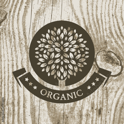 Organic product badge with tree on wooden texture. Vector illust