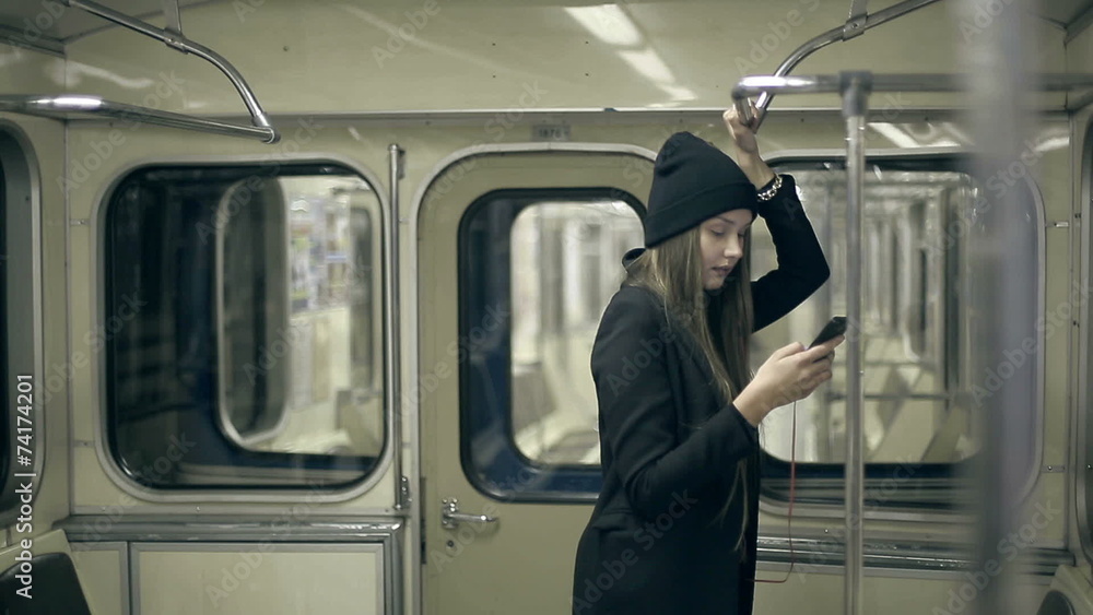 Teen girl rides the subway at night and used smartphone Teen girl rides the subway at night and used smartphone
