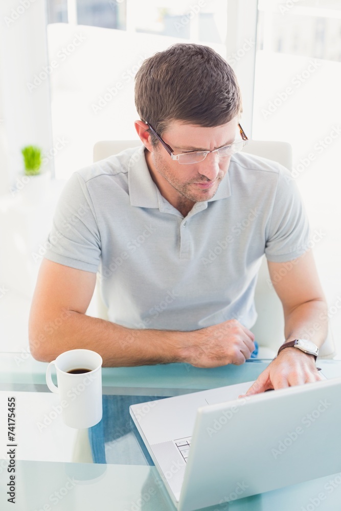 Casual businessman using his laptop at desk Casual businessman using his laptop at desk