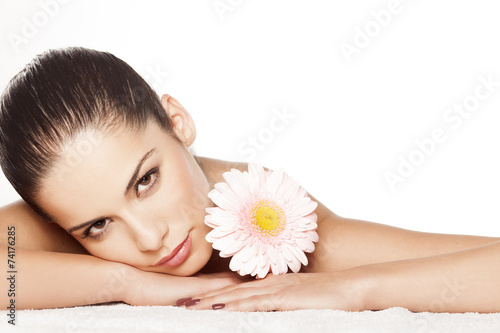 Portrait of lying beautiful young woman with gerbera