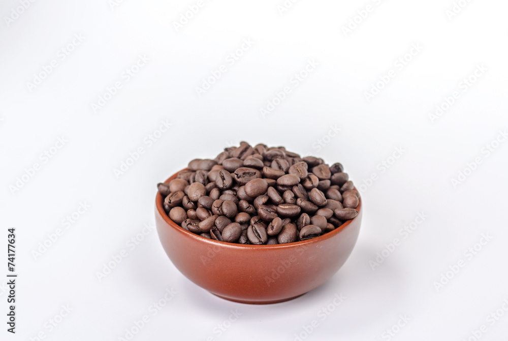 brown bowl with coffee beans on a heap brown bowl with coffee beans on a heap