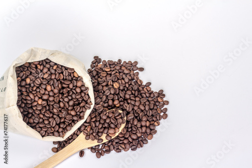 wooden spoon on a background of a full bag of coffee beans