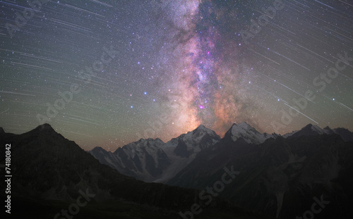 Milky Way and star trails above mountains