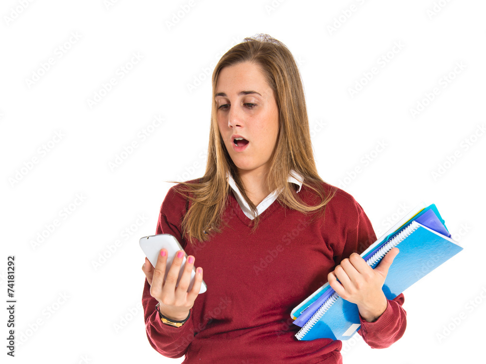 Surprised student talking to mobile over white background Surprised student talking to mobile over white background