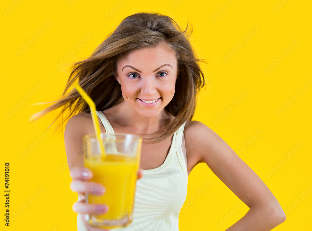 Teenager girl drinking orange juice on yellow background Teenager girl drinking orange juice on yellow background