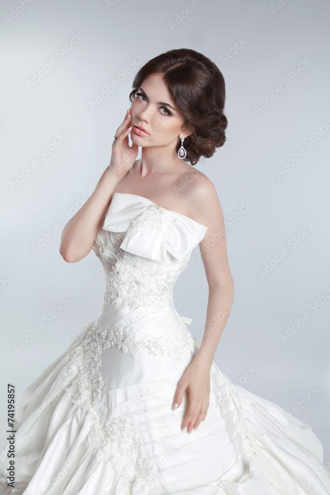 Fashion beauty young bride model posing in wedding dress with ha Fashion beauty young bride model posing in wedding dress with ha