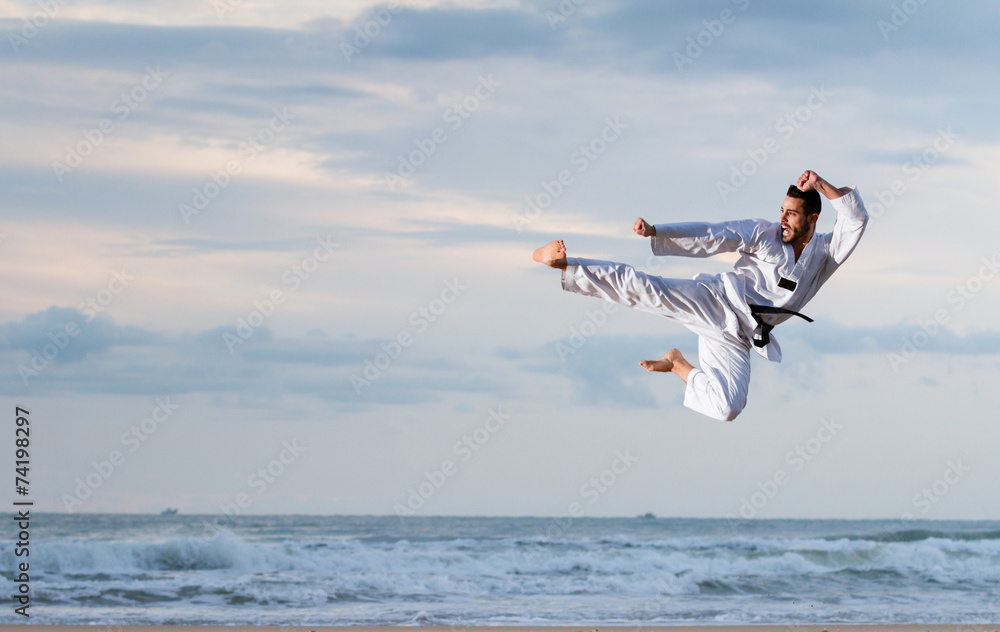 Man jumping to practice Marcial Arts kick Man jumping to practice Marcial Arts kick