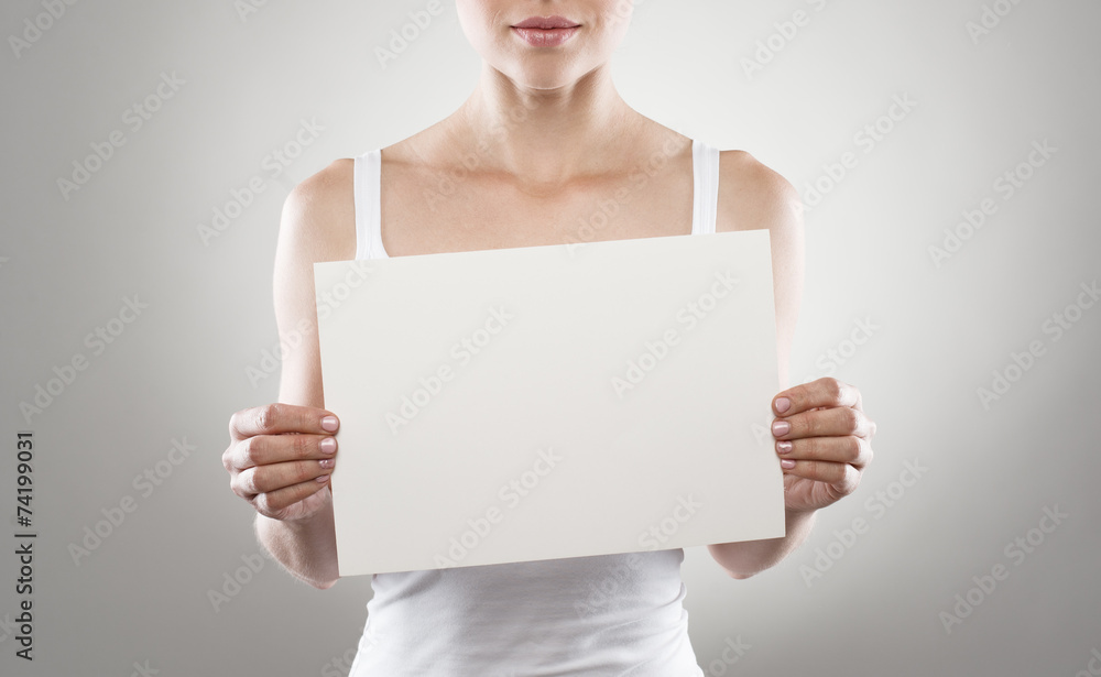 Portrait of young slim female holding blank paper sheet Portrait of young slim female holding blank paper sheet