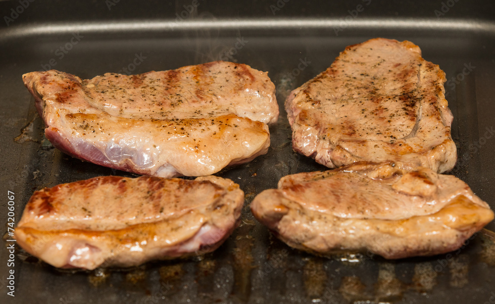 steaks grilling in a pan