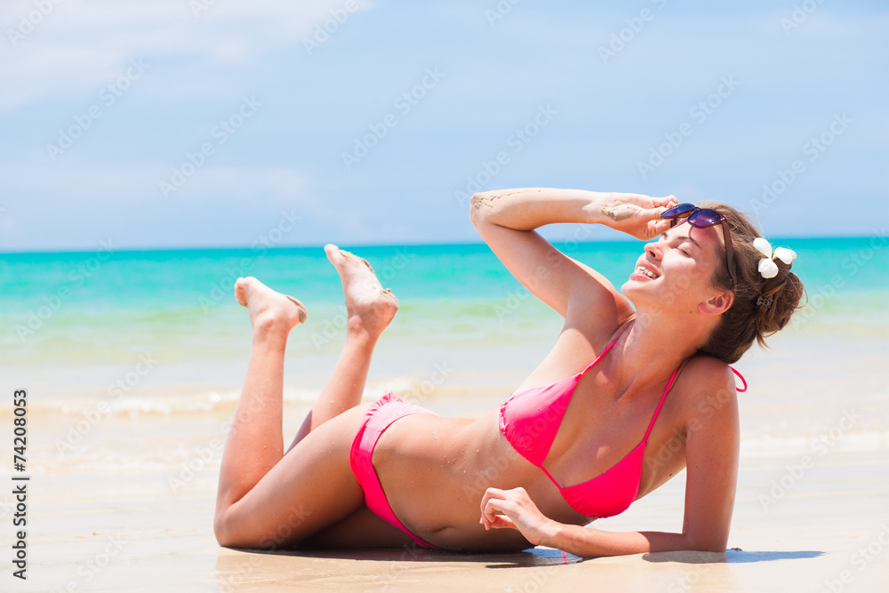 fit woman in bikini with flower in hair on tropical beach fit woman in bikini with flower in hair on tropical beach