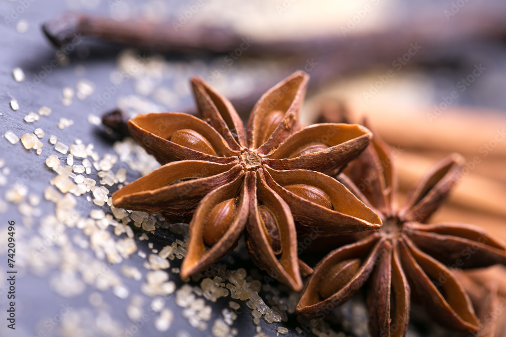 Star anise with cinnamon sticks over black stones background Star anise with cinnamon sticks over black stones background