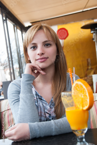 Cuttest blond on earth in coffee shop drinking orange juice