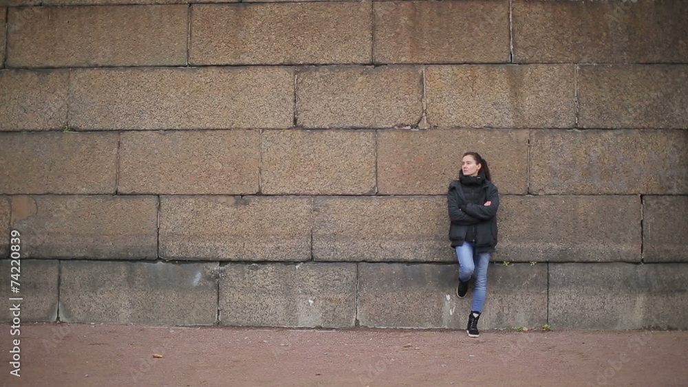 ong shot of the girl near the stone wall ong shot of the girl near the stone wall