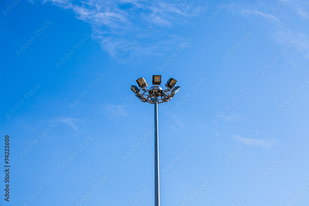 Lamp or sports lighting on tall lamppost with blue sky Lamp or sports lighting on tall lamppost with blue sky