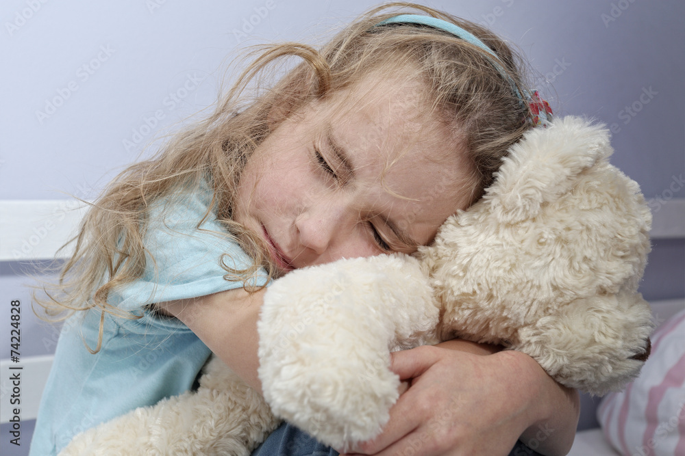 sad lonely girl sitting in the room hugging teddy