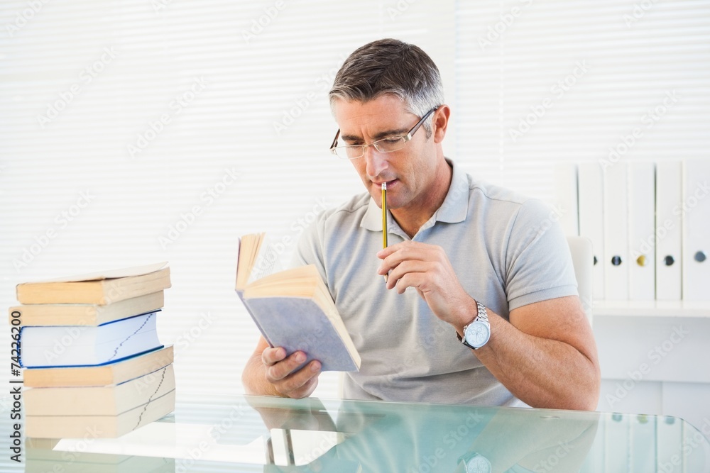 Man with glasses thinking and reading a book Man with glasses thinking and reading a book