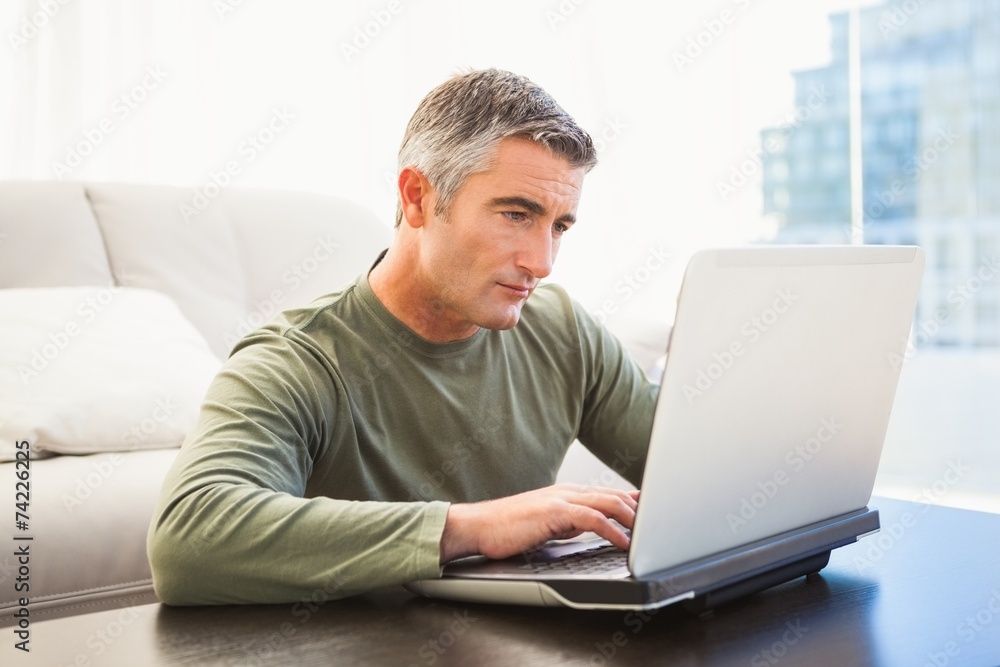 Concentrated man with grey hair using laptop Concentrated man with grey hair using laptop