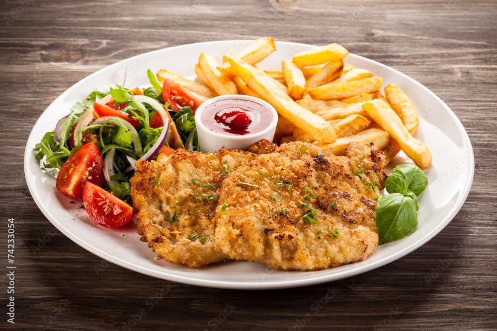 Pork chop, French fries and vegetables Pork chop, French fries and vegetables