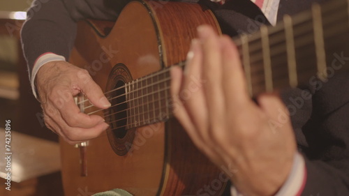 Classical guitarist playing an arpeggio on classic guitar photo